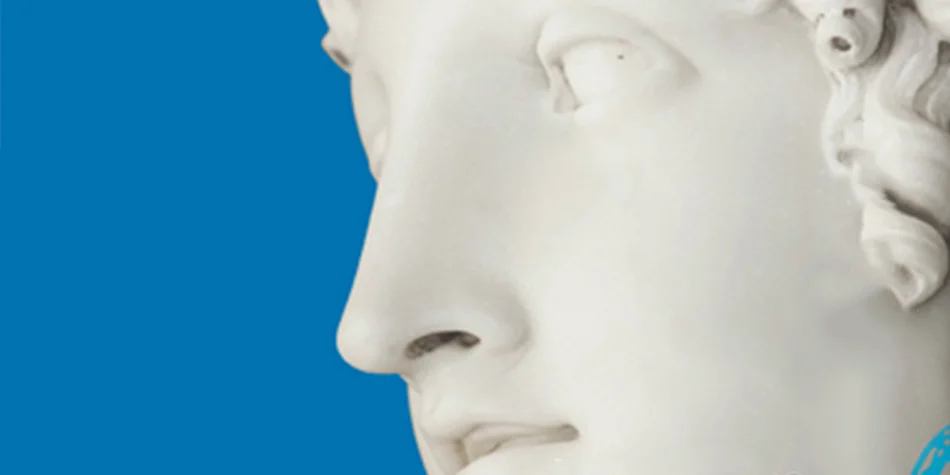 Photo du visage d'une statue de marbre sur fond bleu