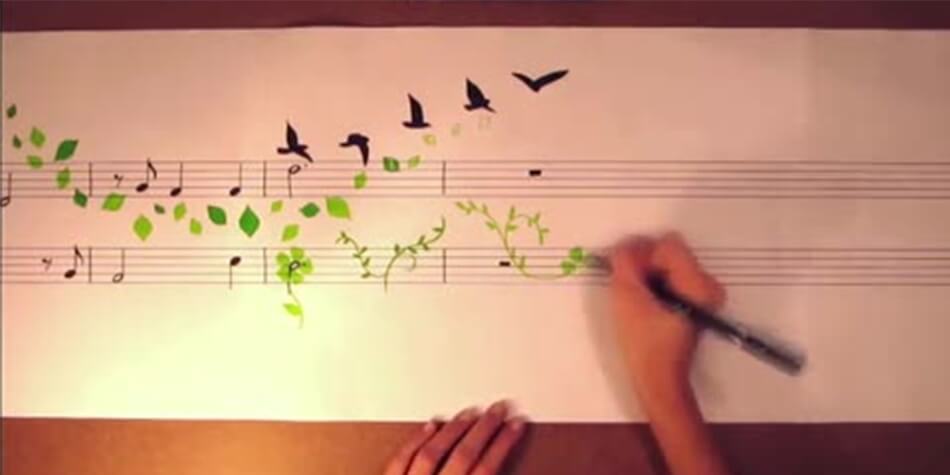 Hands drawing birds and flowers on sheet music
