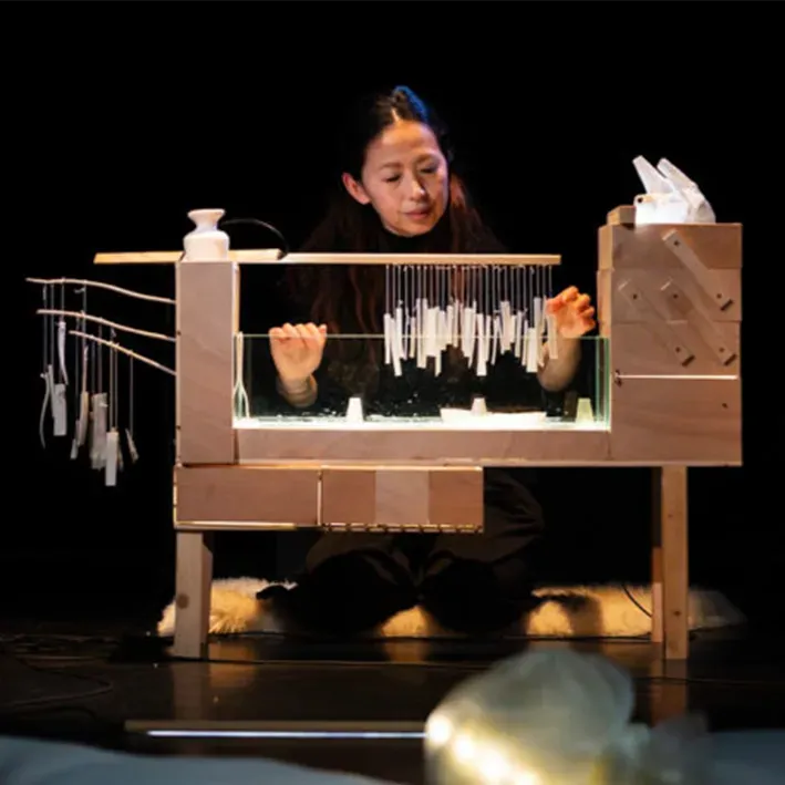 Photo de Ayako Okubo jouant d'un étrange instrument sur scène