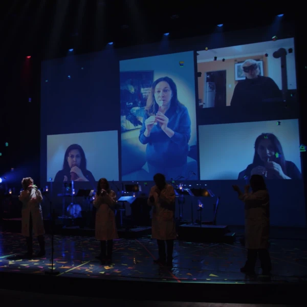Photo du concert avec en fond un aperçu de la chorale sur écran